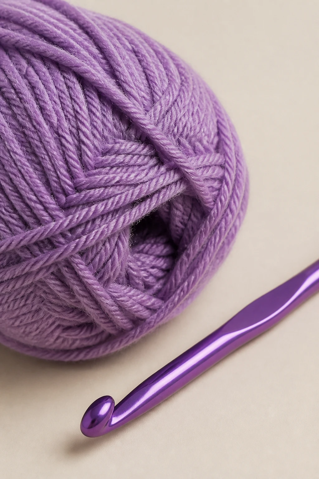 Closeup of a crochet hook and single yarn skein on a plain backdrop