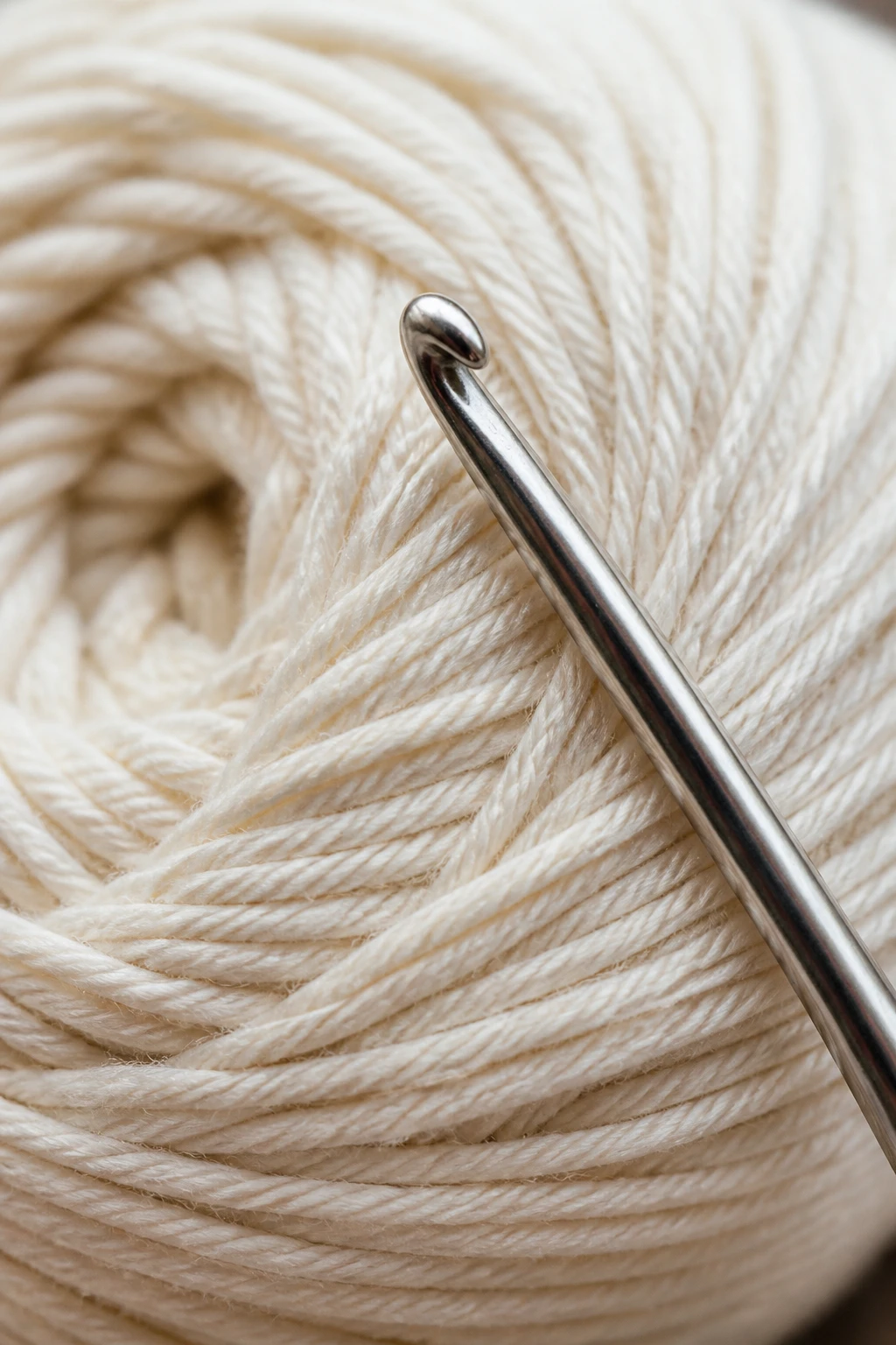 closeup ball of cotton yarn and metal crochet hook