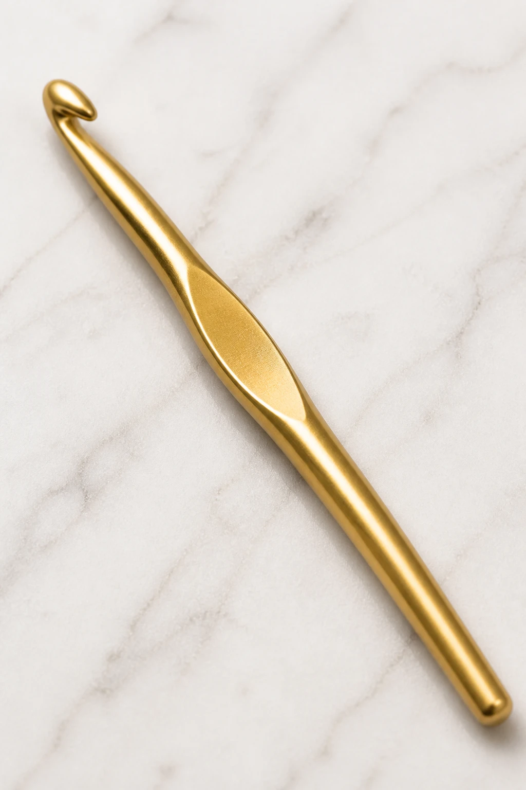 Closeup of a single H-8 crochet hook with labeled size on a bright surface