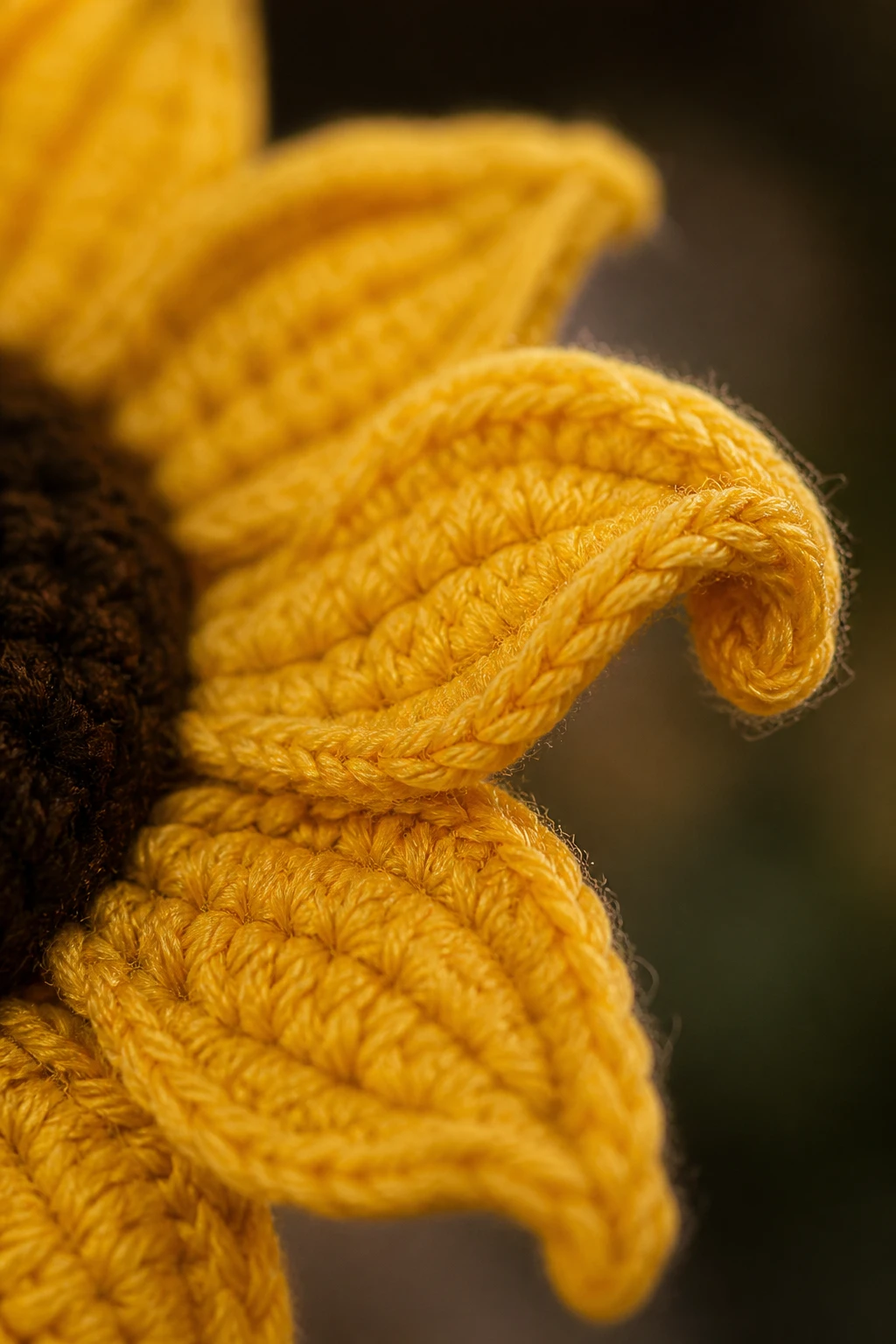 Macro shot of a single crocheted sunflower petal detail and edge curl