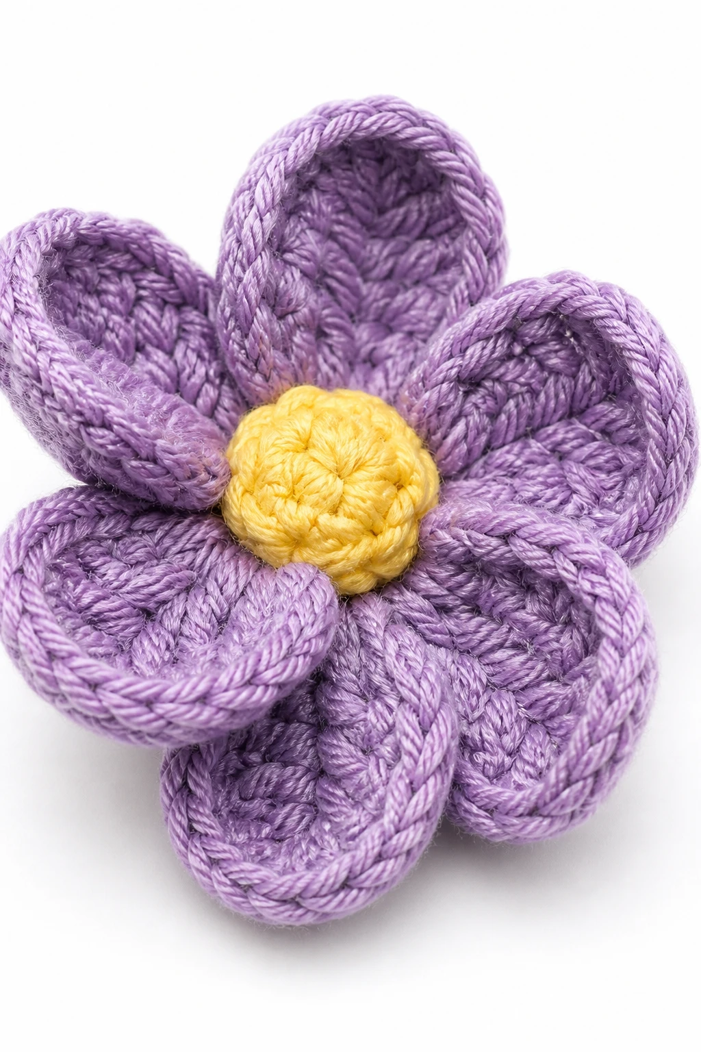 Closeup of a single crocheted flower with stiffened petals, macro on white background