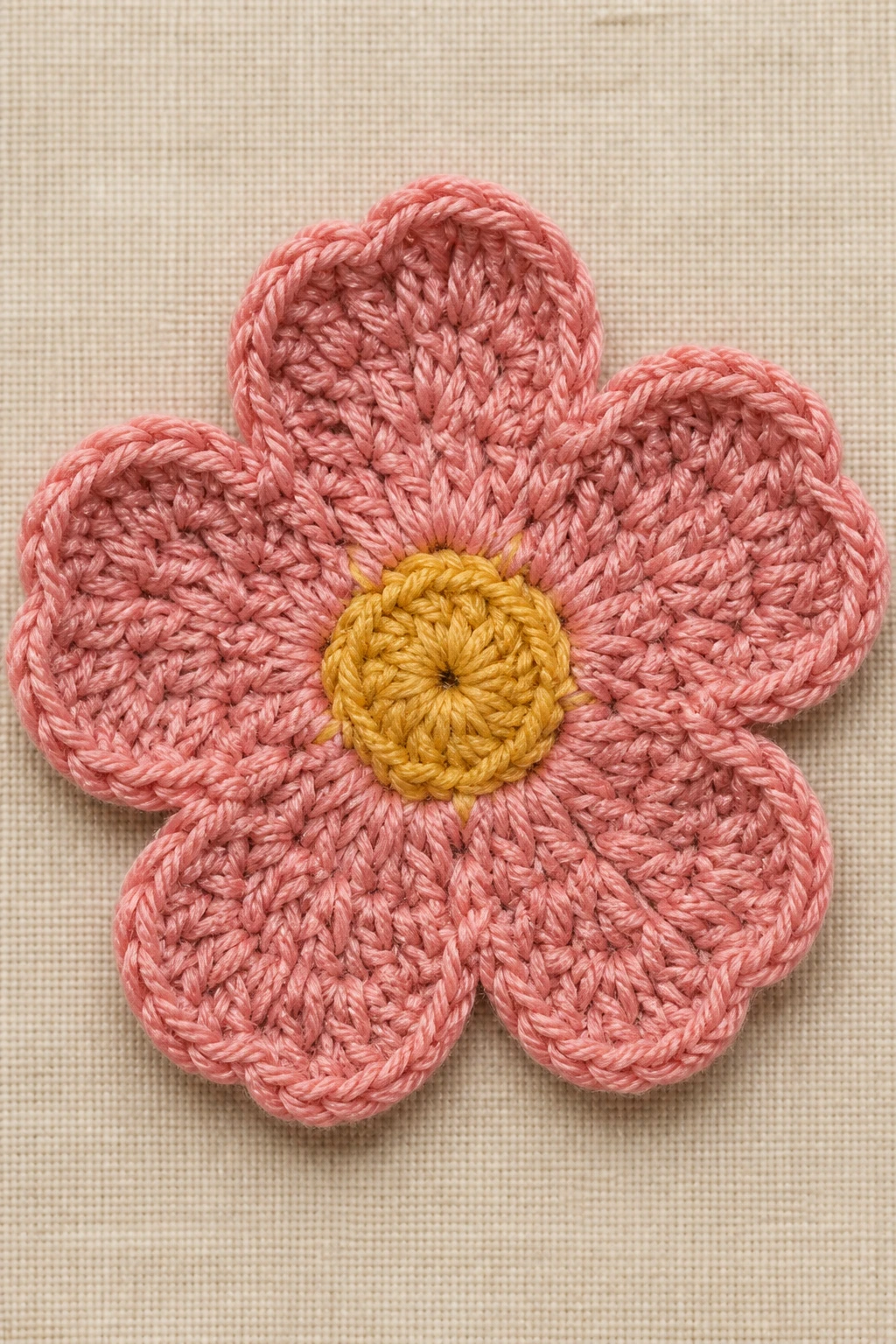 Closeup of flat crochet flower on fabric background