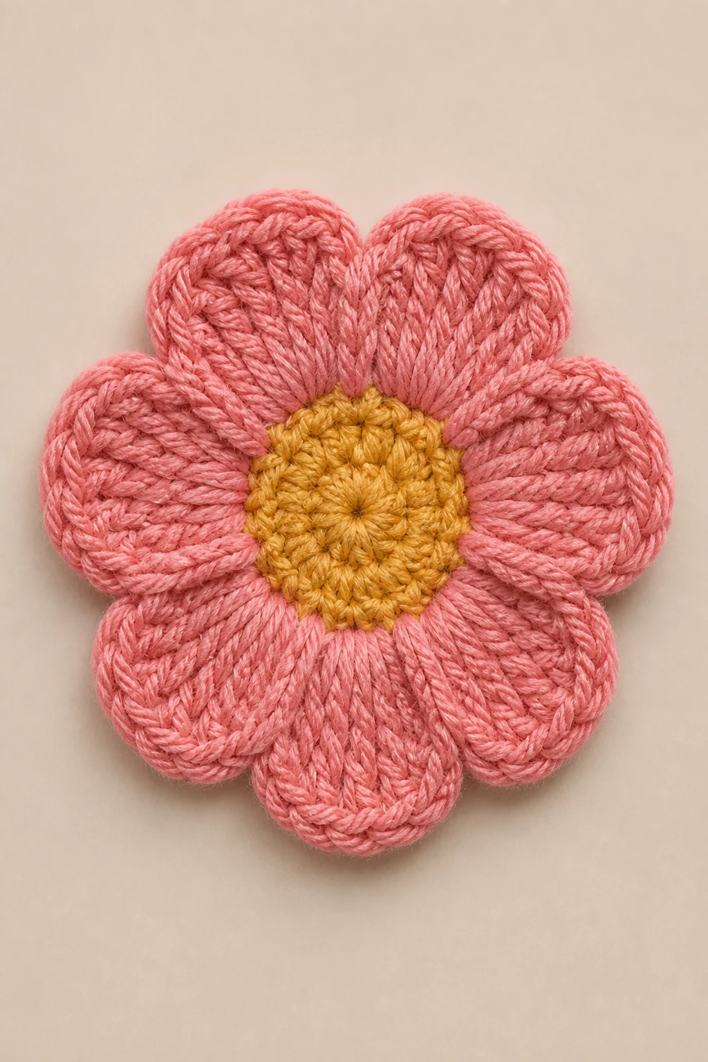closeup of a centered crochet flower with even stitches on neutral background