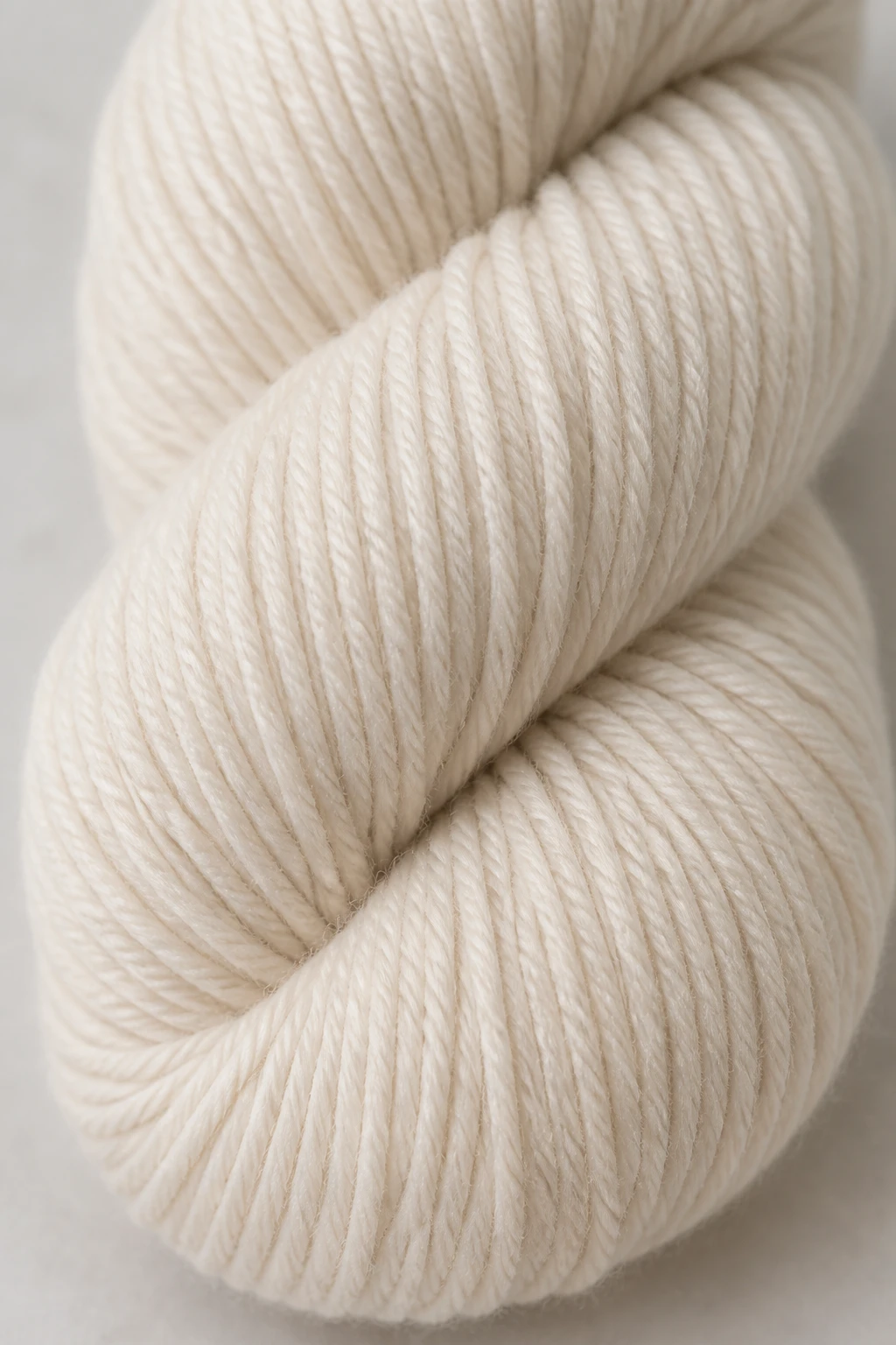 Closeup of worsted weight yarn skein in pale color with label visible