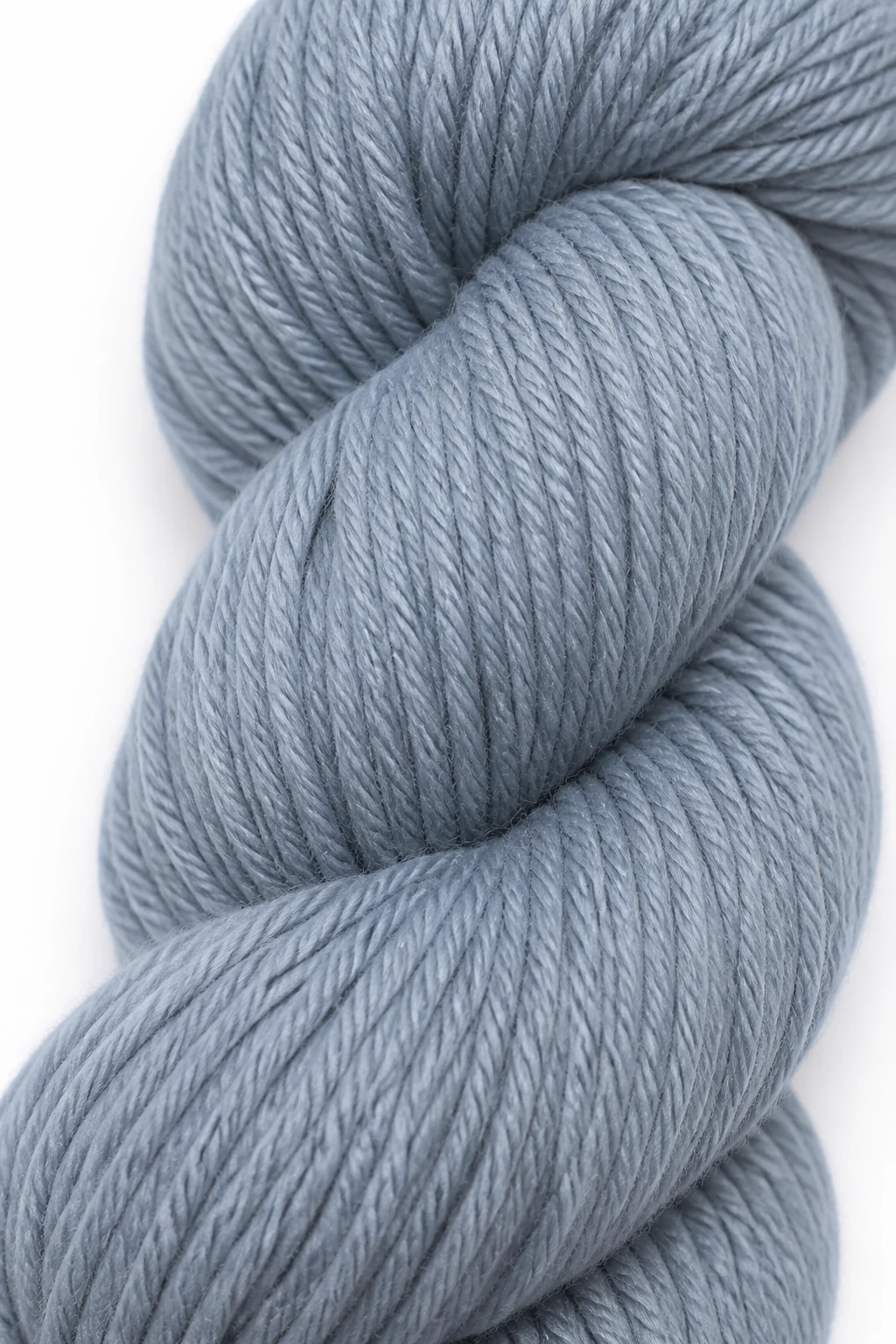 Closeup of worsted weight yarn skein with smooth fibers on white