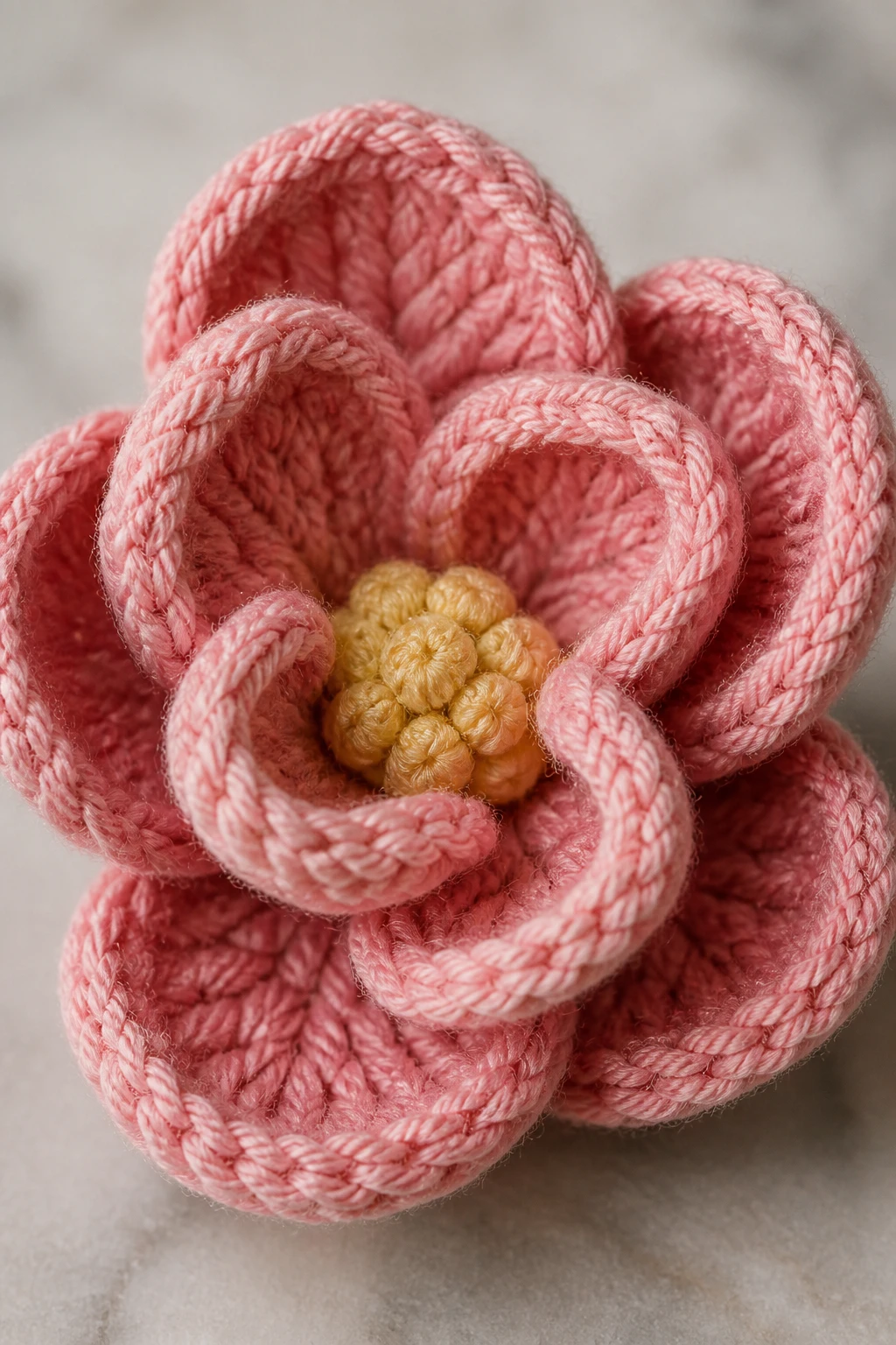 closeup of a single 3D crochet flower with curled petals, textured stitches