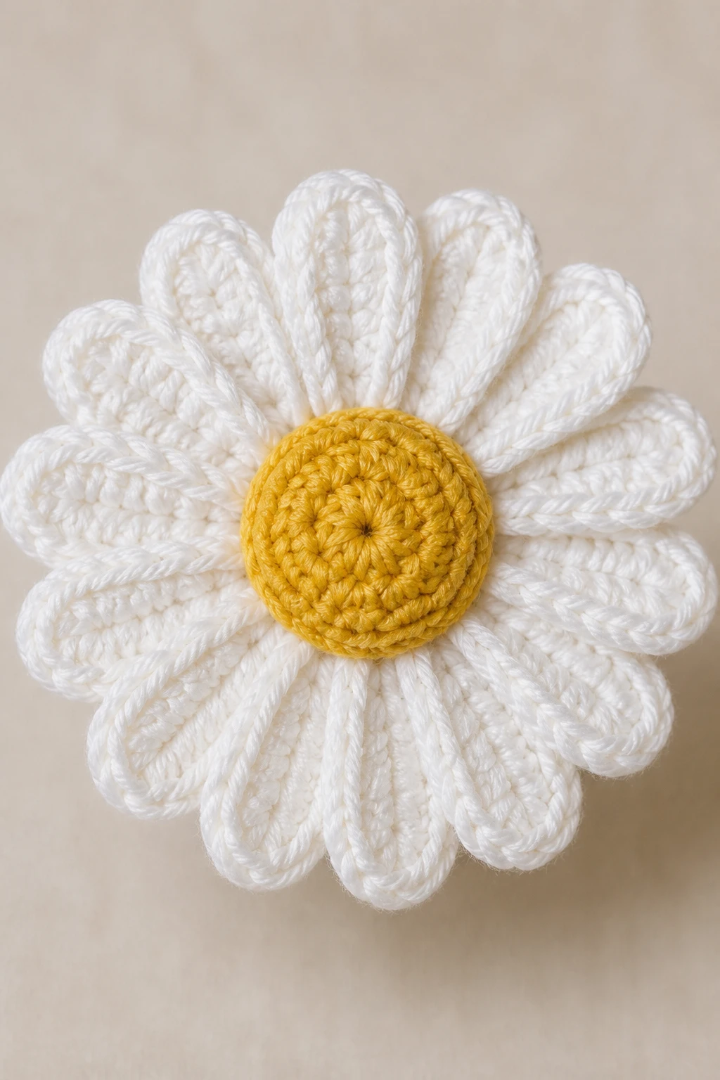 Closeup of a single crochet daisy bloom on neutral background