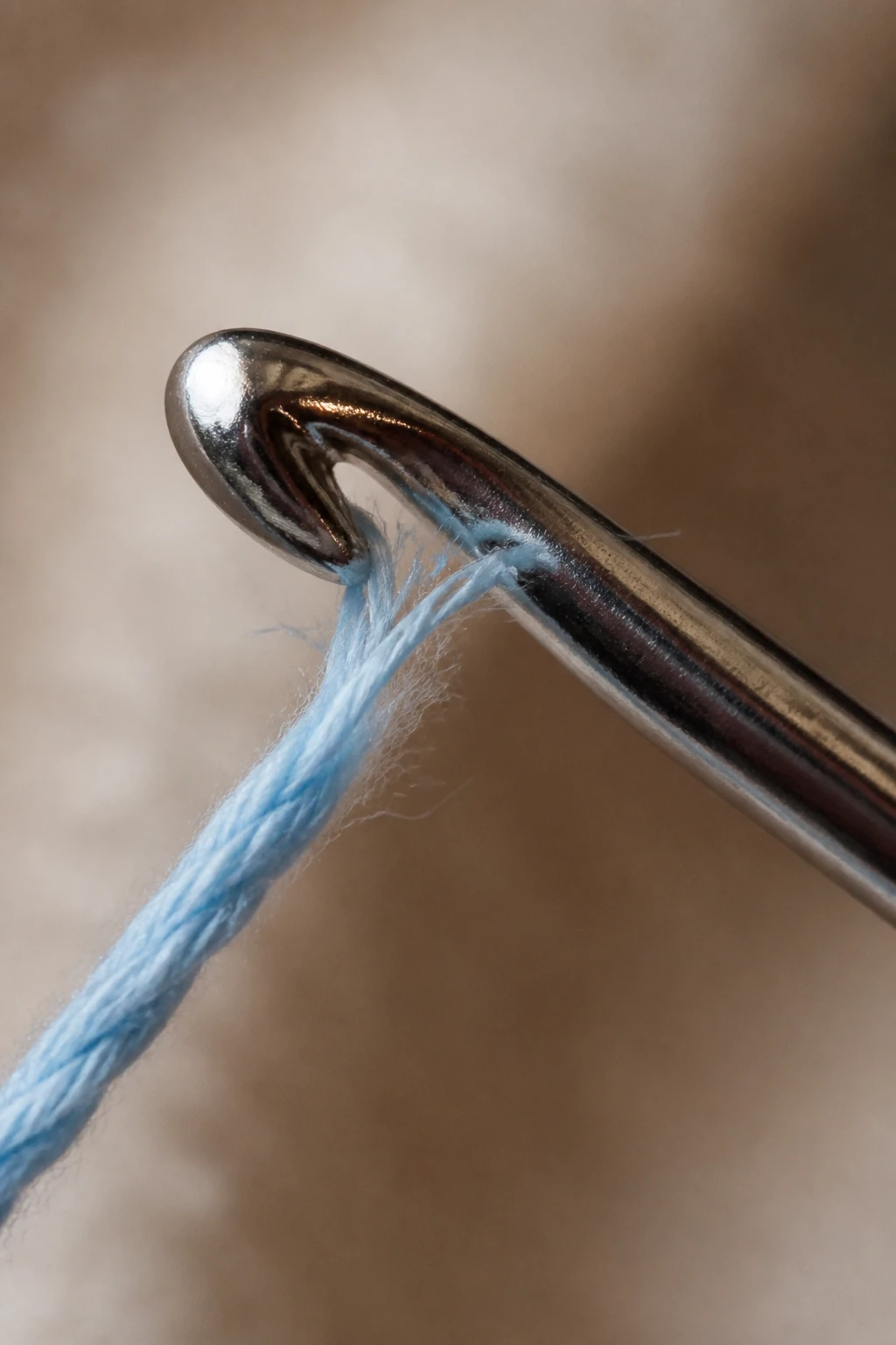 Closeup of a single crochet hook catching split yarn fiber