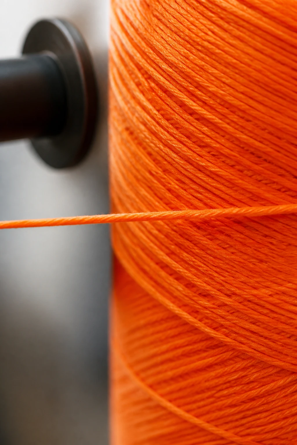 Closeup of smooth single-ply yarn strand being wound, bright color