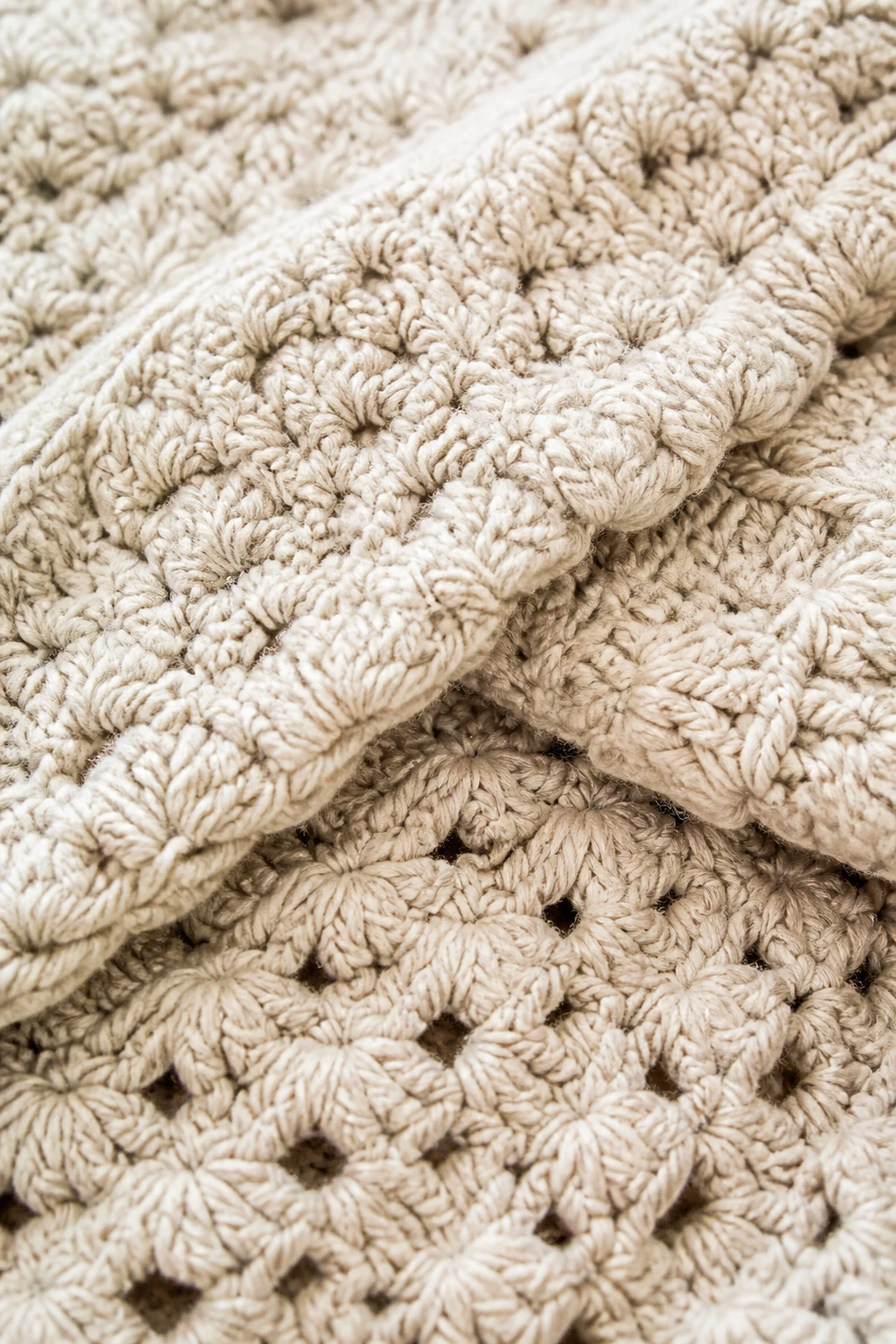 Macro shot of a plush crochet throw folded to reveal texture