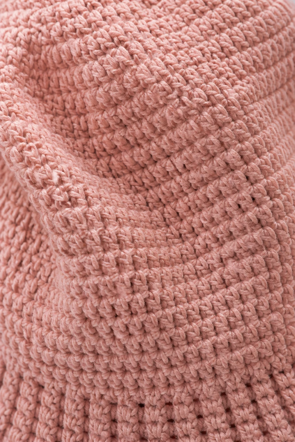 Macro shot of crochet hat texture showing even stitches and drape