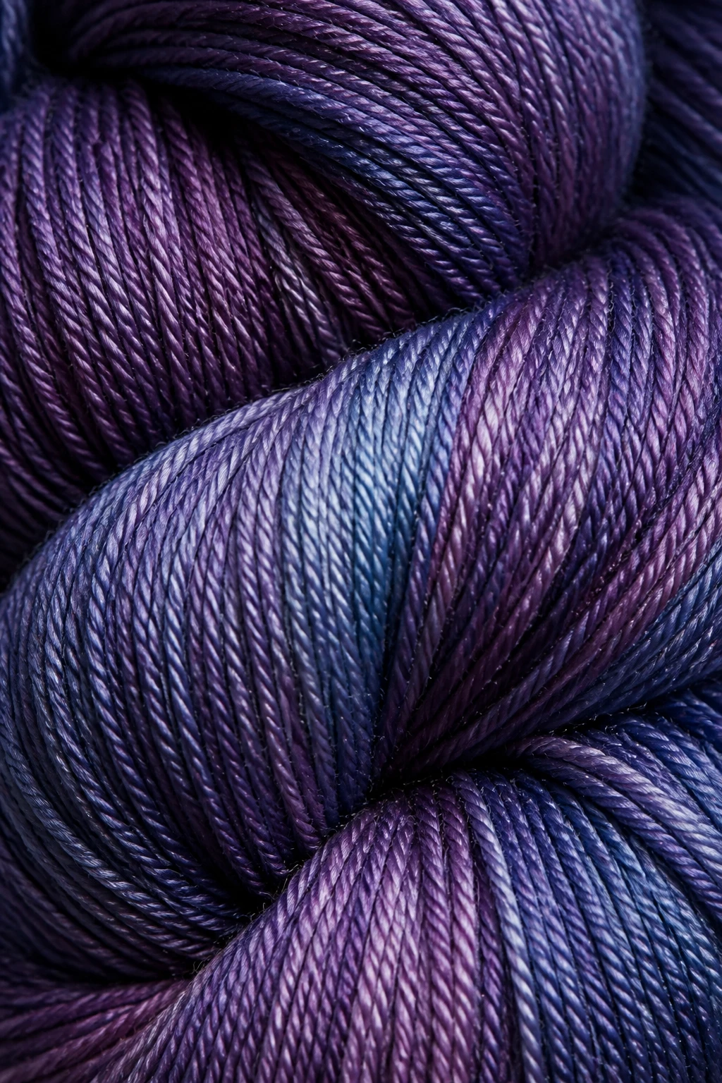 Tight focus on glossy, tightly wound skein showing subtle sheen and fine fiber plies